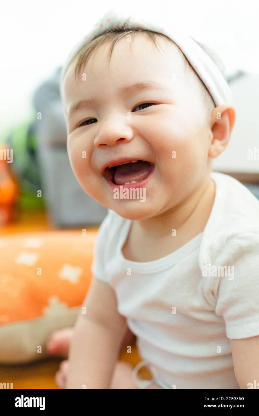Close-up portrait of adorable Asian baby girl smiling at camera Stock Photo