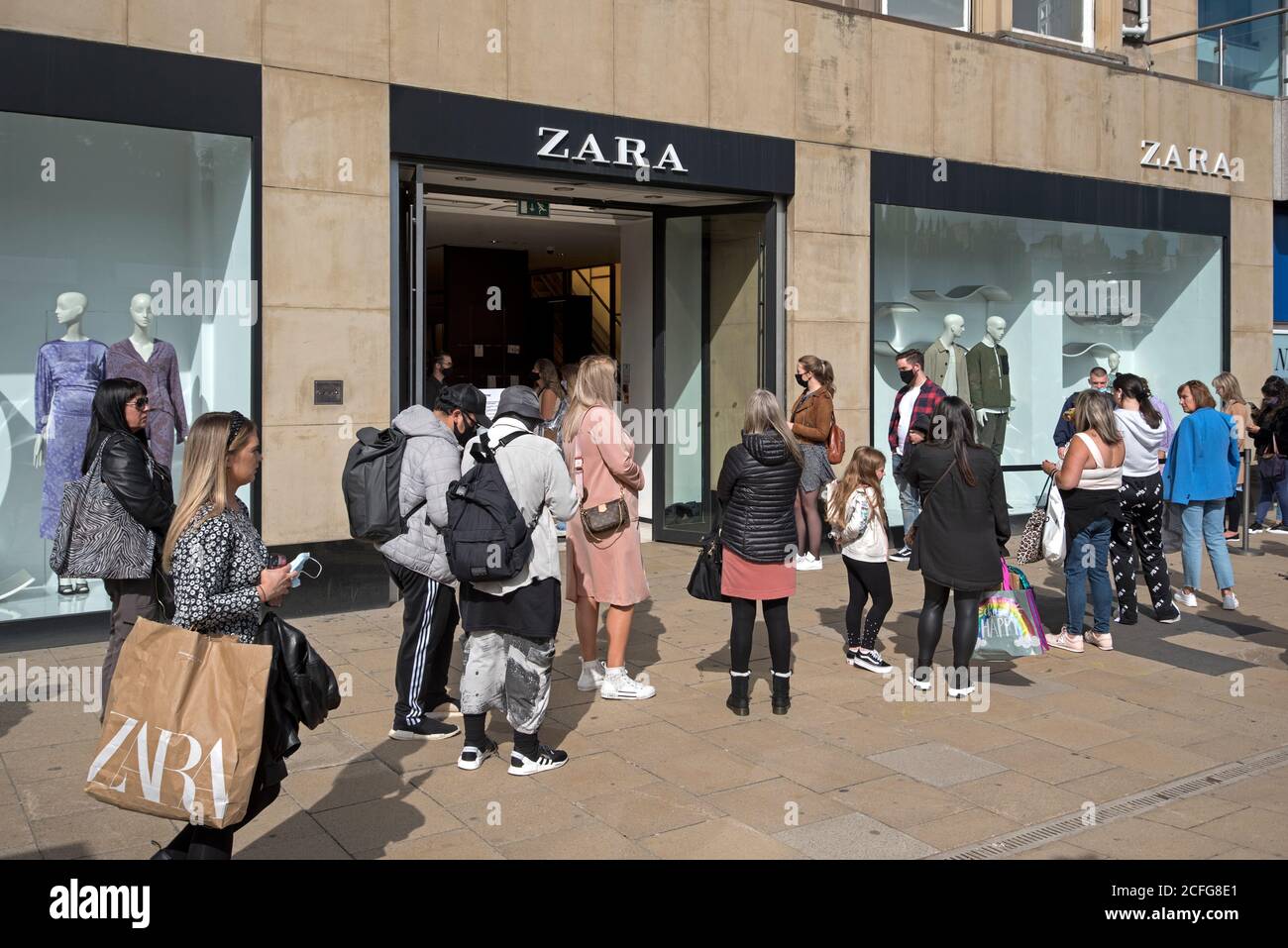 Customers queueing outside the Zara store on Princes Street, Edinburgh, Scotland, UK. Stock Photo