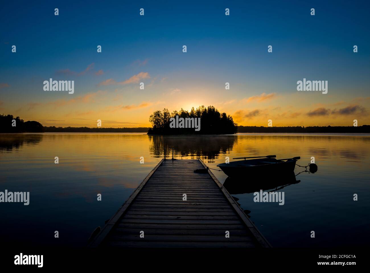 Sonnenaufgang am schwedischem See mit einem Boot als Panorama Stock Photo