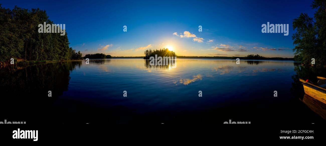 Sonnenaufgang am schwedischem See mit einem Boot als Panorama Stock Photo