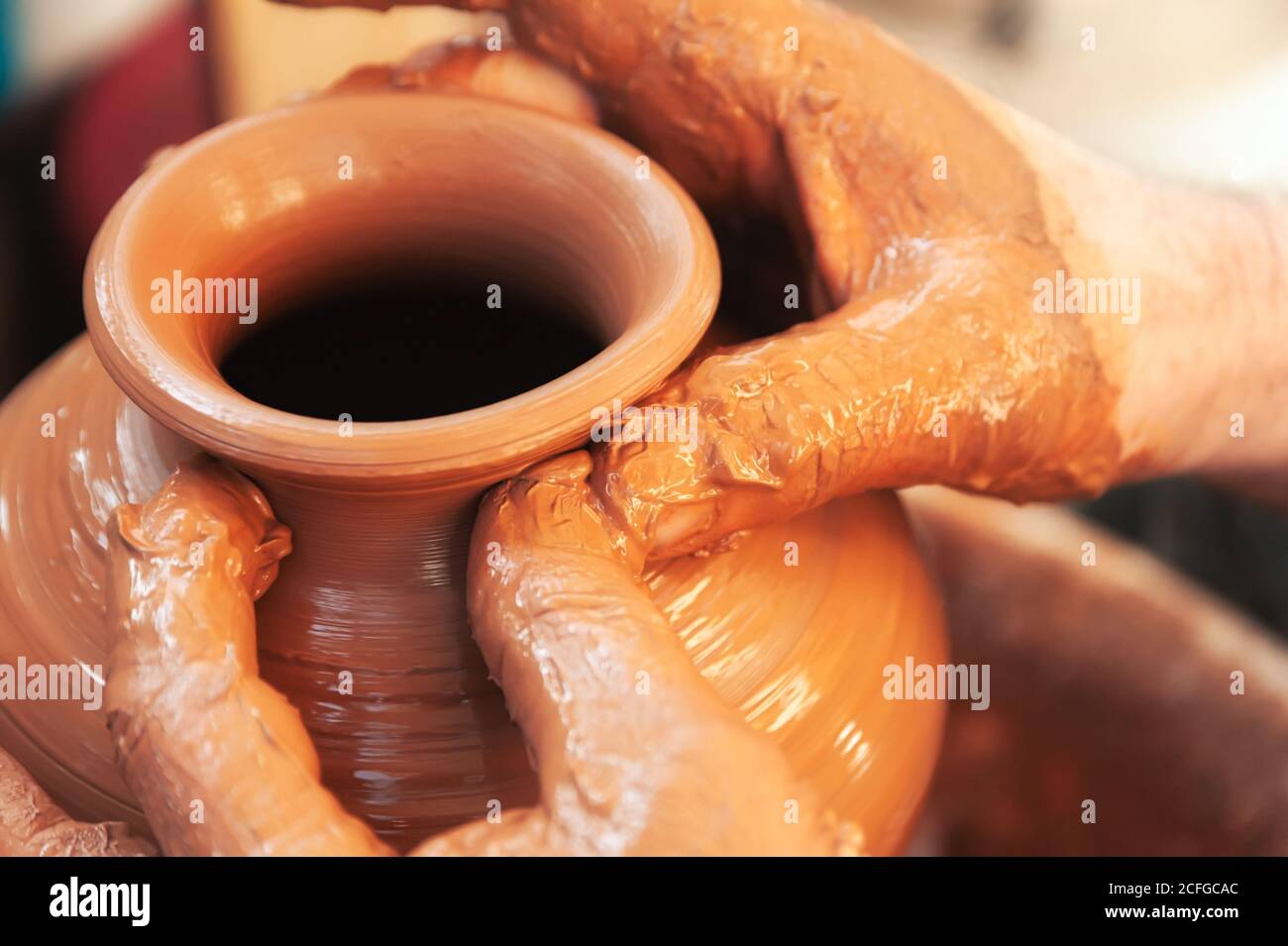 Closeup anonymous craftsman making vase from clay while working in professional pottery Stock Photo
