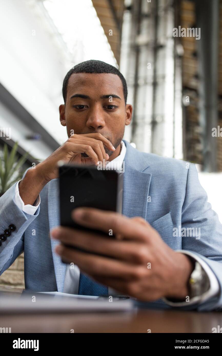man using smartphone sitting at table Stock Photo
