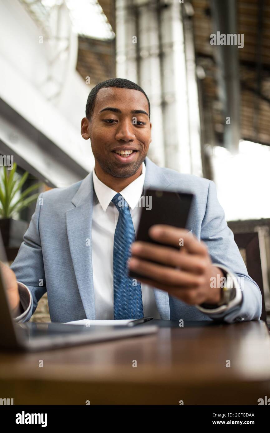 man using smartphone sitting at table Stock Photo