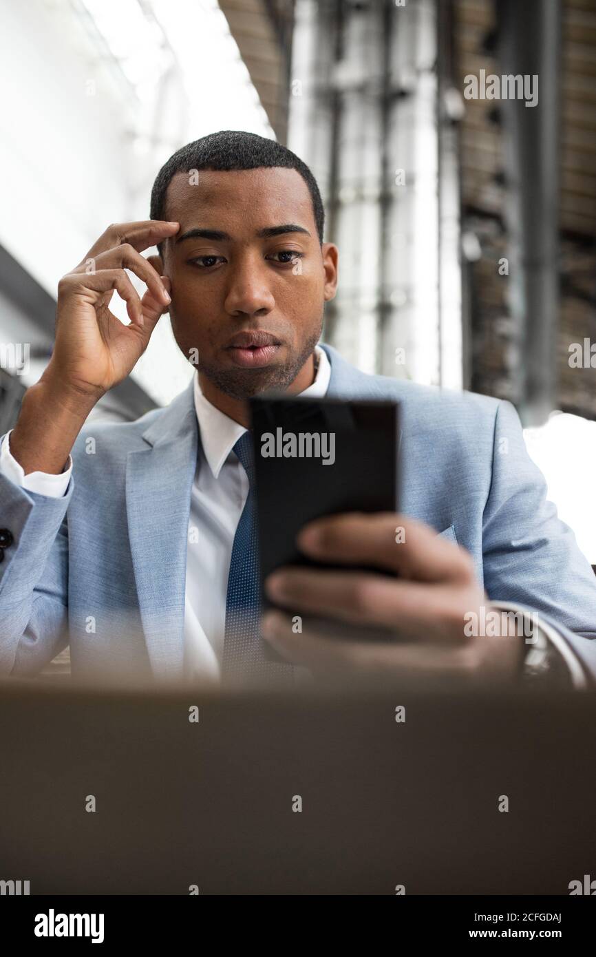 man using smartphone sitting at table Stock Photo