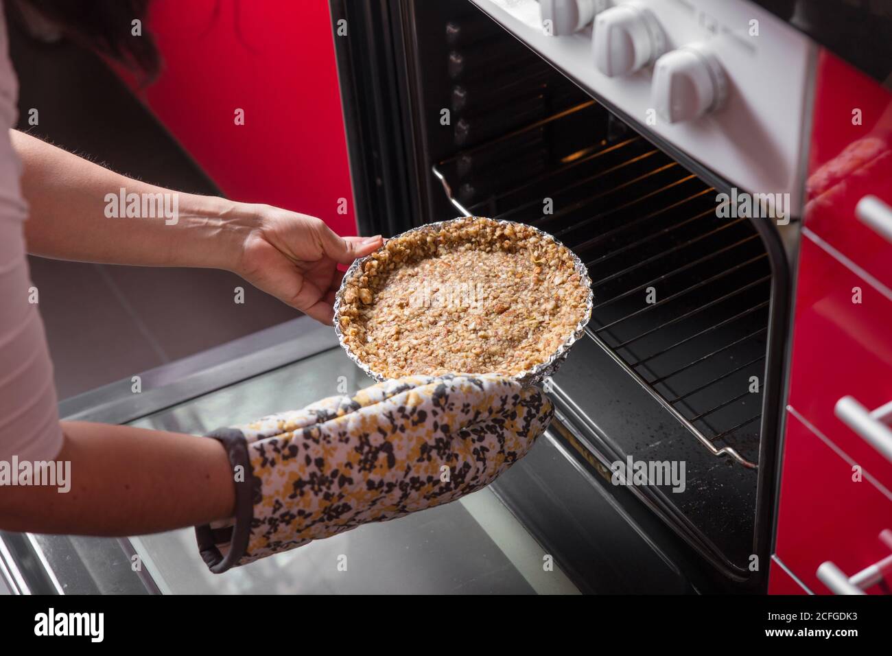 Woman putting a cake in the oven Stock Photo