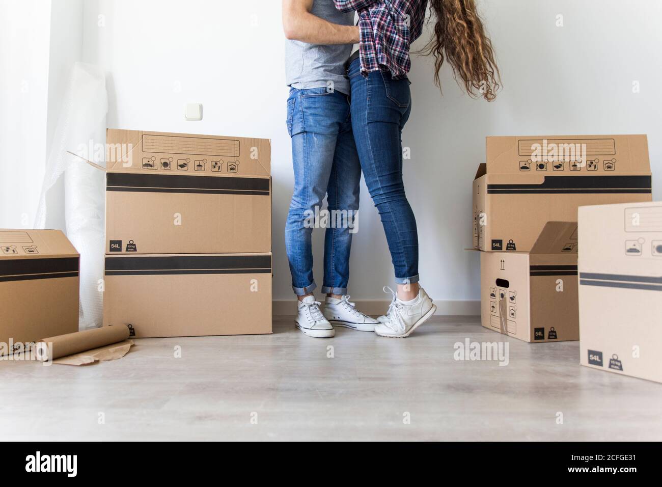 Hugging Boxes Crop view of couple in casual clothes hugging standing in room with ...
