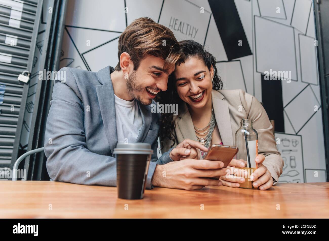 Couple using phone at a bar Stock Photo