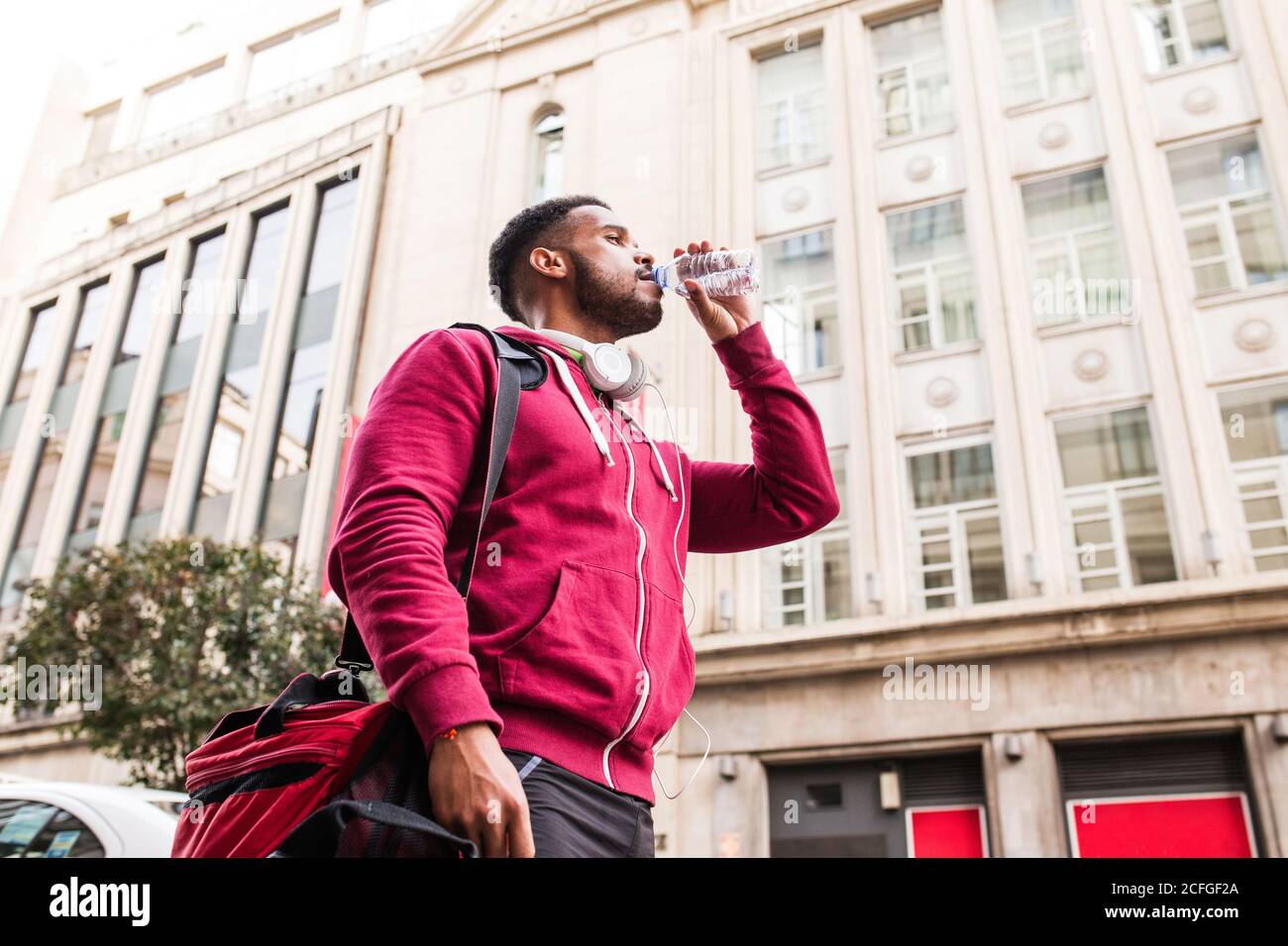 Sporty young man drinking water in the street Stock Photo