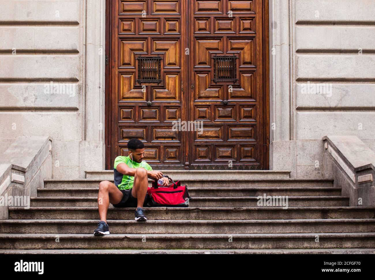 Young man sitting on stairs hi-res stock photography and images - Alamy