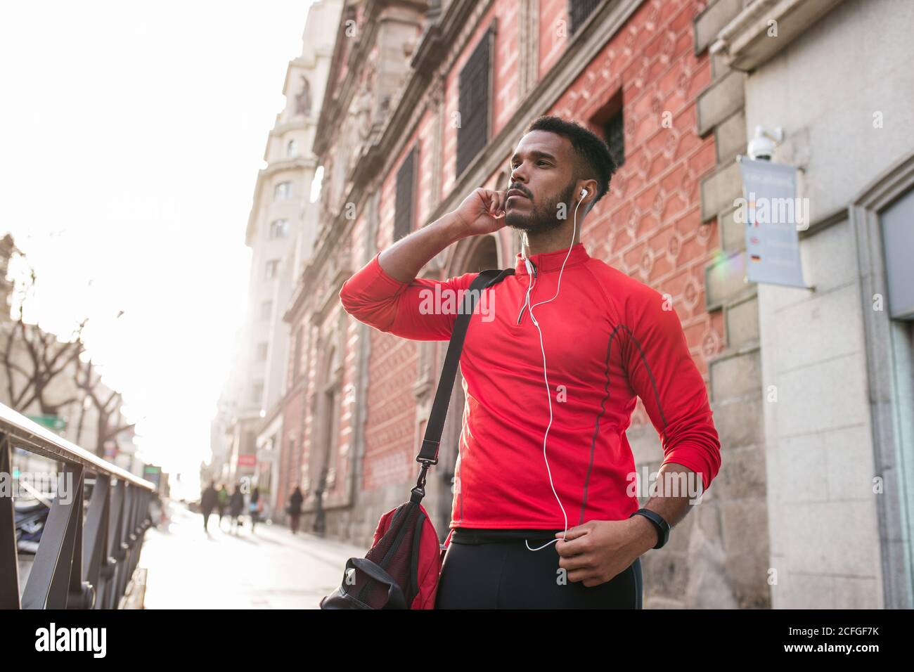 Young man around the city adjusting earphones Stock Photo