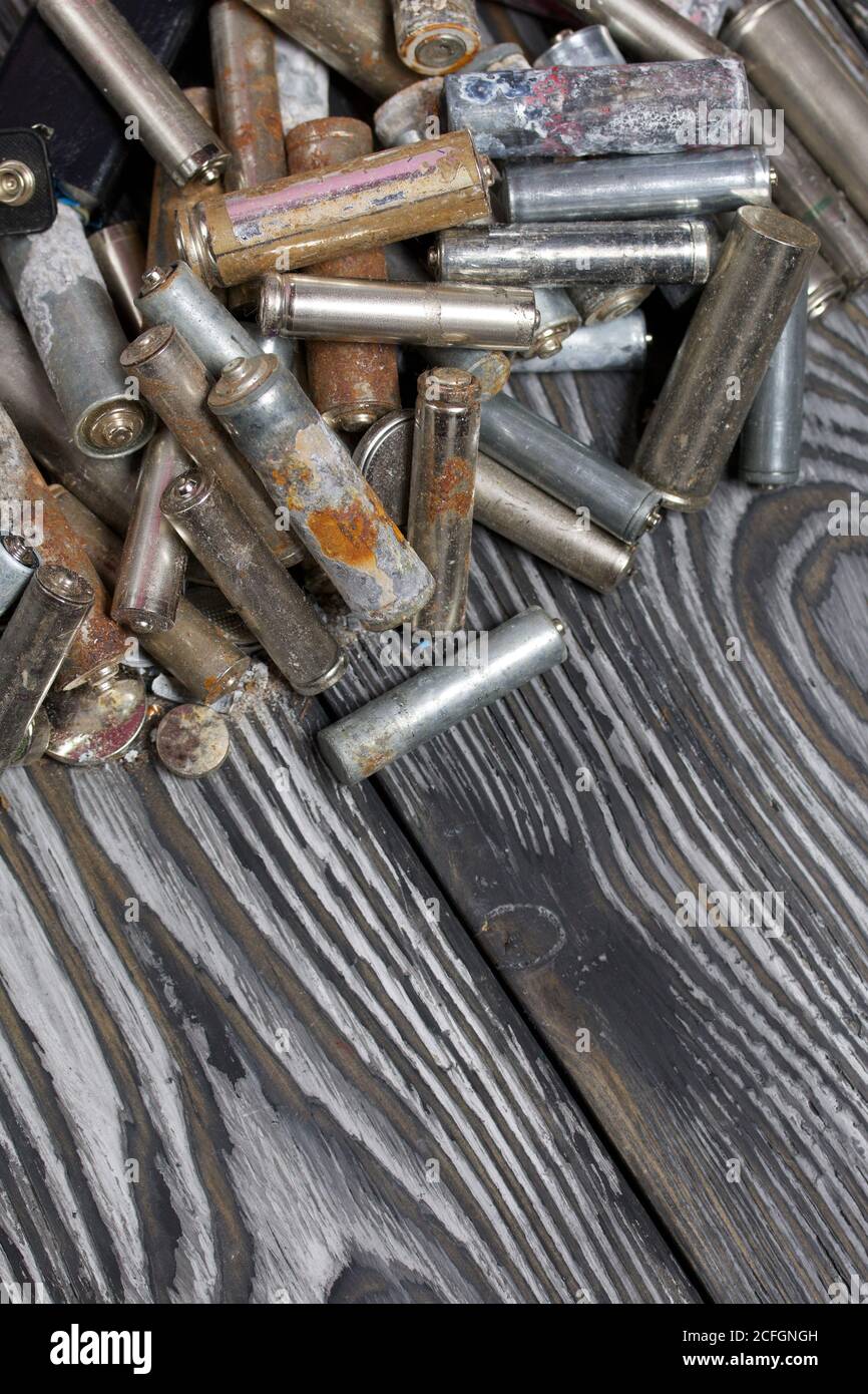 Corroded used batteries. On pine boards. Disposal of hazardous waste