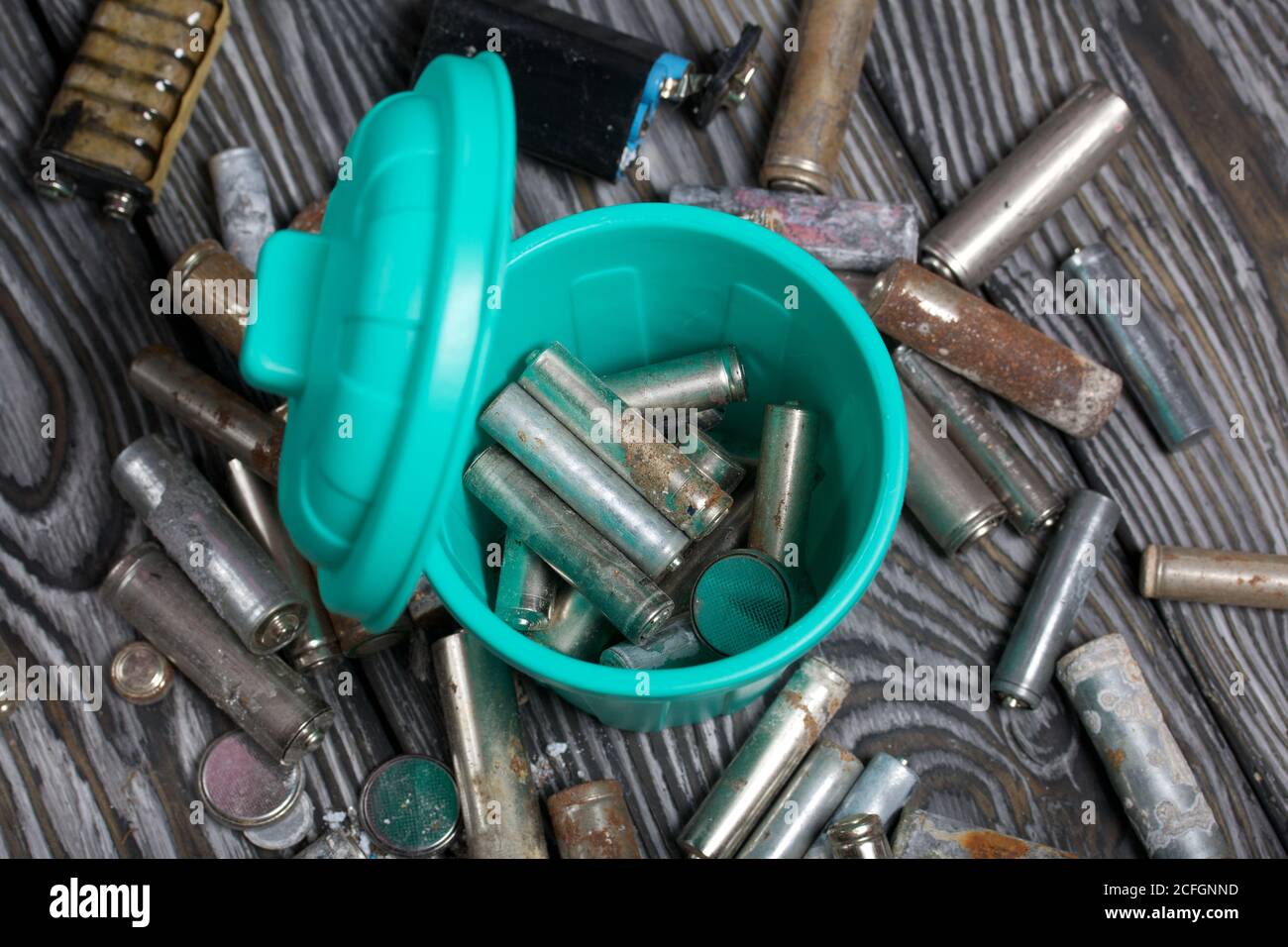 Corroded used batteries. They lie in and around the trash can. Disposal