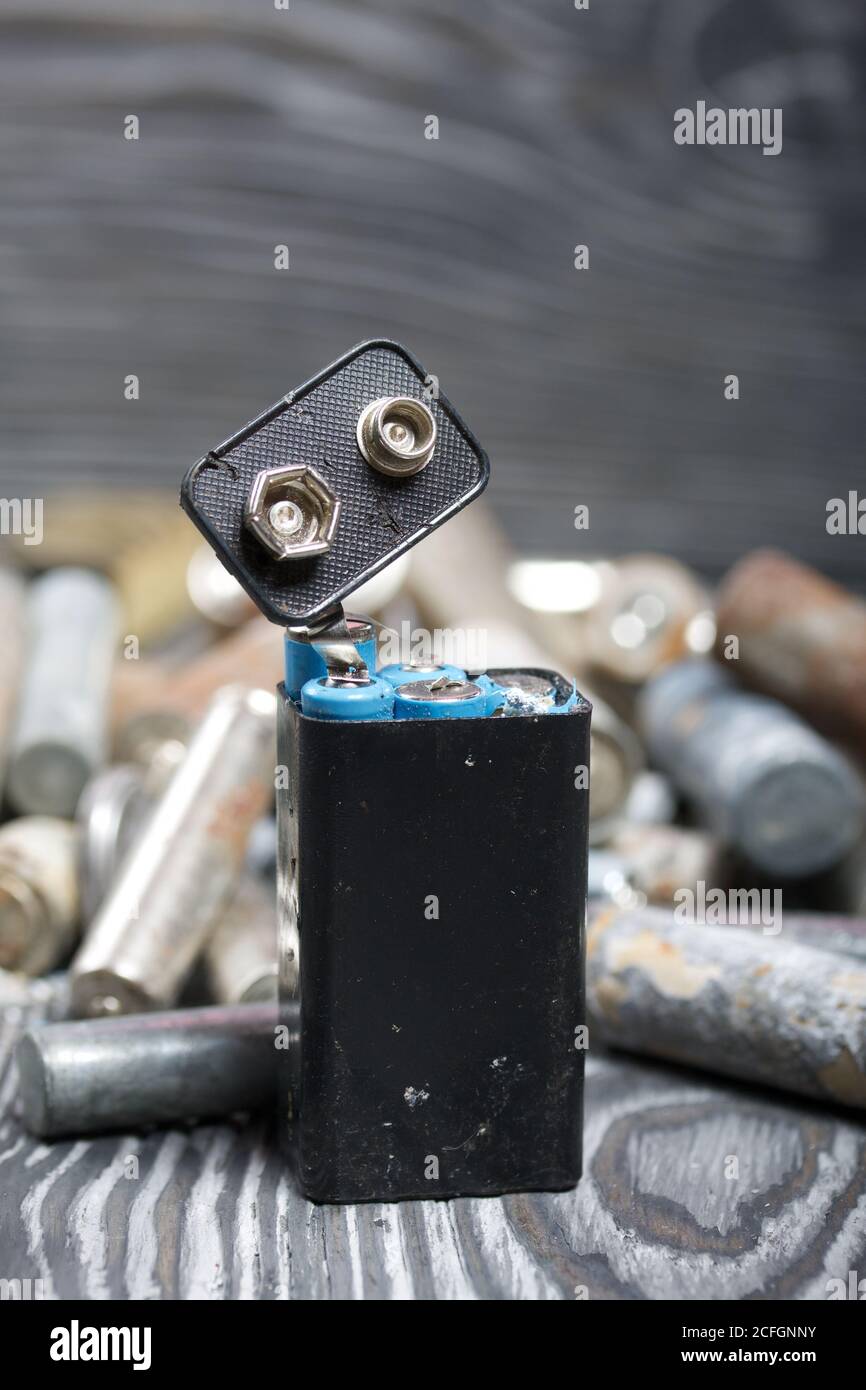 Corroded used batteries. On pine boards. Disposal of hazardous waste