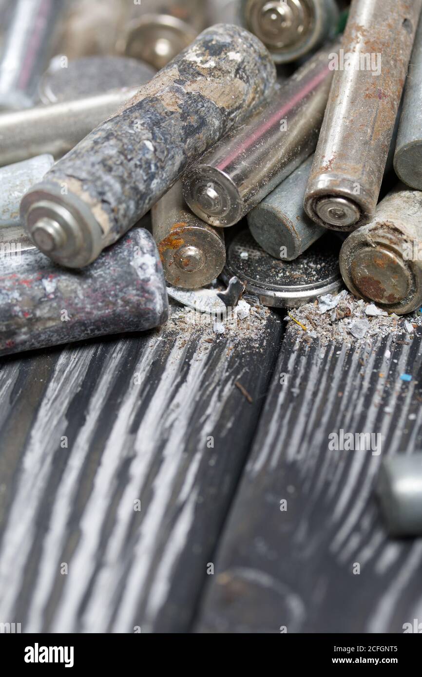 Corroded used batteries. On pine boards. Disposal of hazardous waste