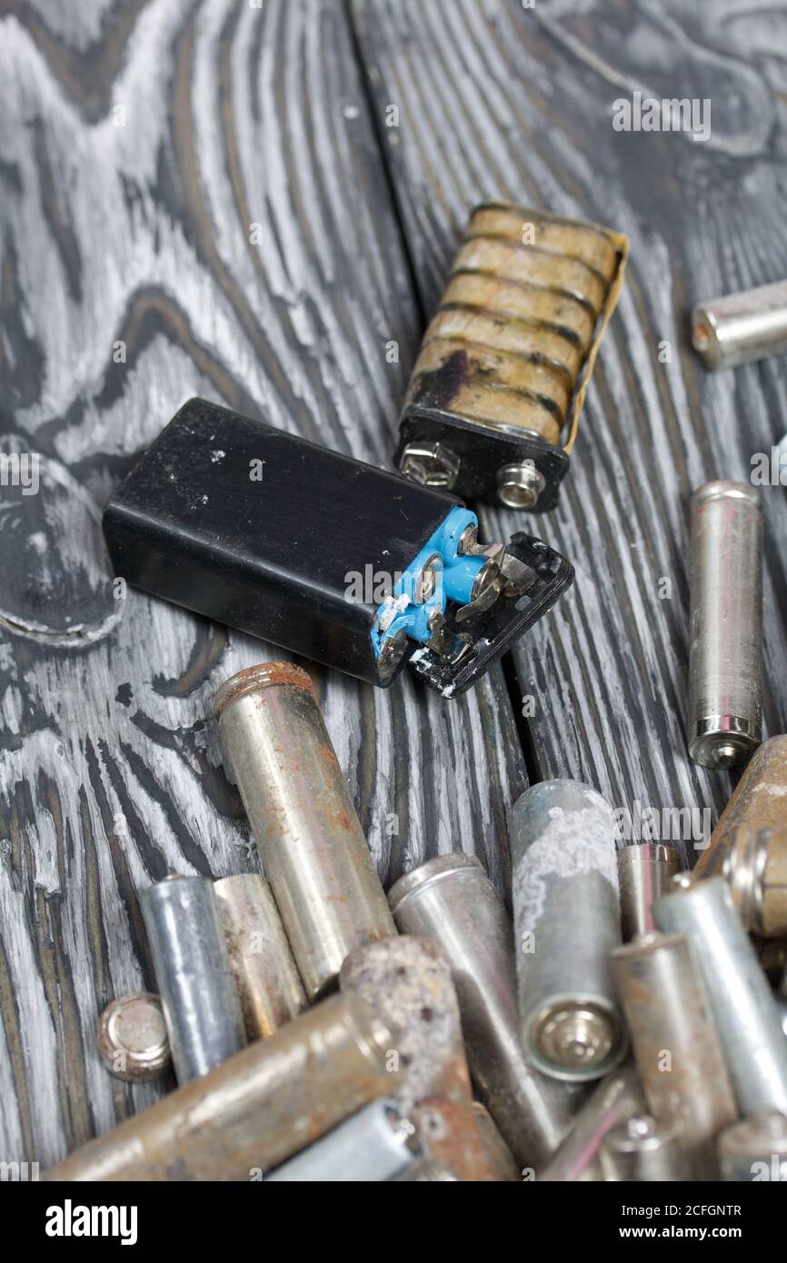 Corroded used batteries. On pine boards. Disposal of hazardous waste