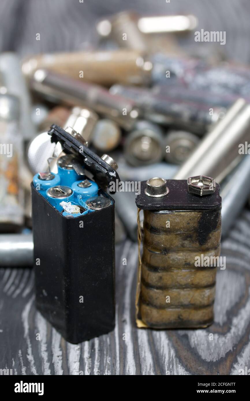 Corroded used batteries. On pine boards. Disposal of hazardous waste