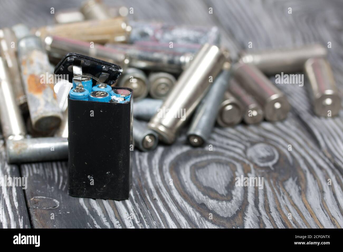 Corroded used batteries. On pine boards. Disposal of hazardous waste