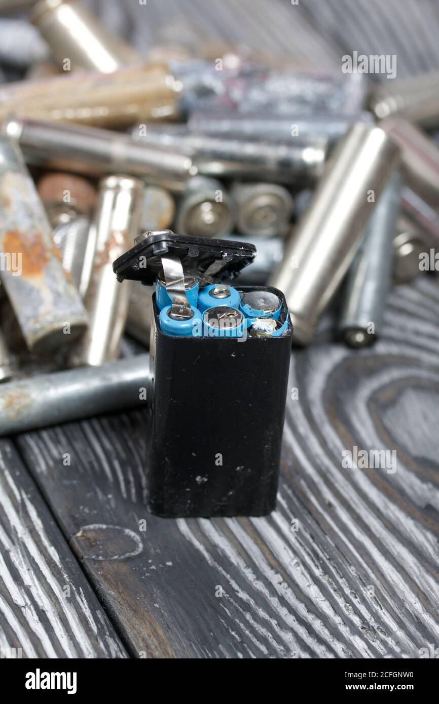 Corroded used batteries. On pine boards. Disposal of hazardous waste