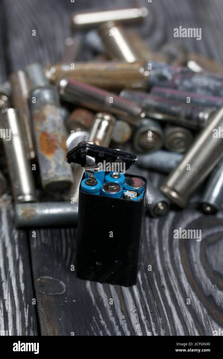 Corroded used batteries. On pine boards. Disposal of hazardous waste