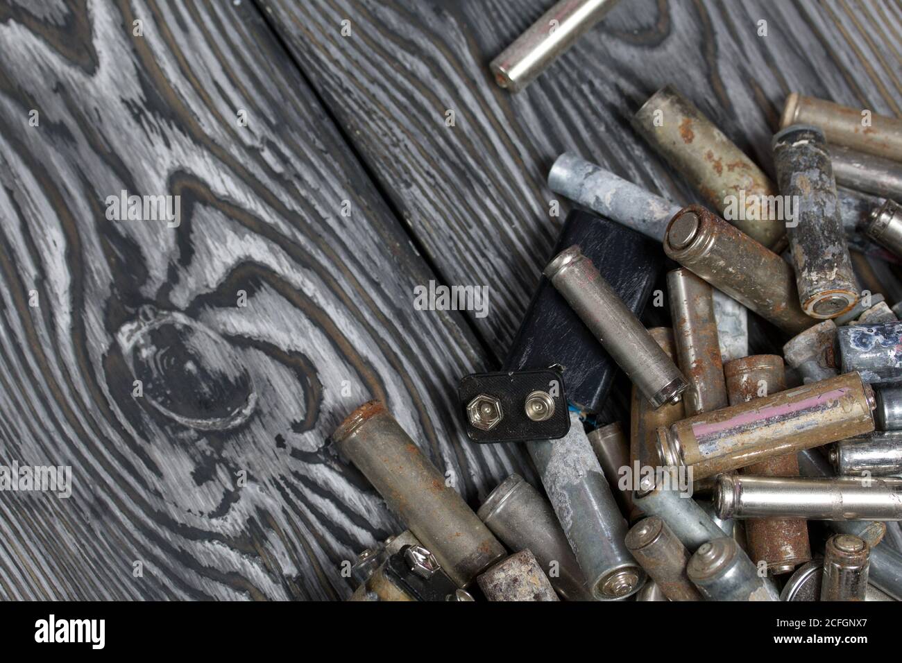 Corroded used batteries. On pine boards. Disposal of hazardous waste