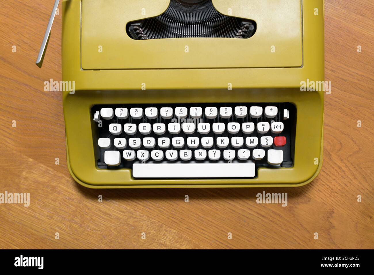 Top down view on the alphanumeric keyboard of an old retro typewriter on a wooden desk in a communication or business concept Stock Photo
