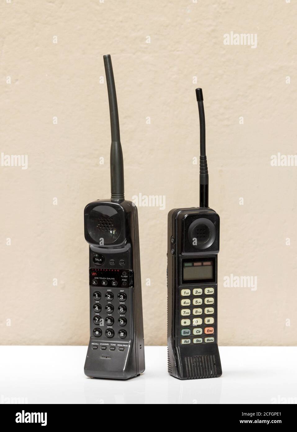 Two old black vintage mobile phones with antennae and numerical keypads standing side by side in a communication concept Stock Photo