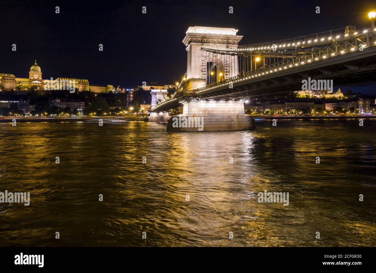 Chain Bridge over the Danube at night: The Széchenyi Chain Bridge in central Budapest with the Palace and Buda in the background all lit at night. Stock Photo