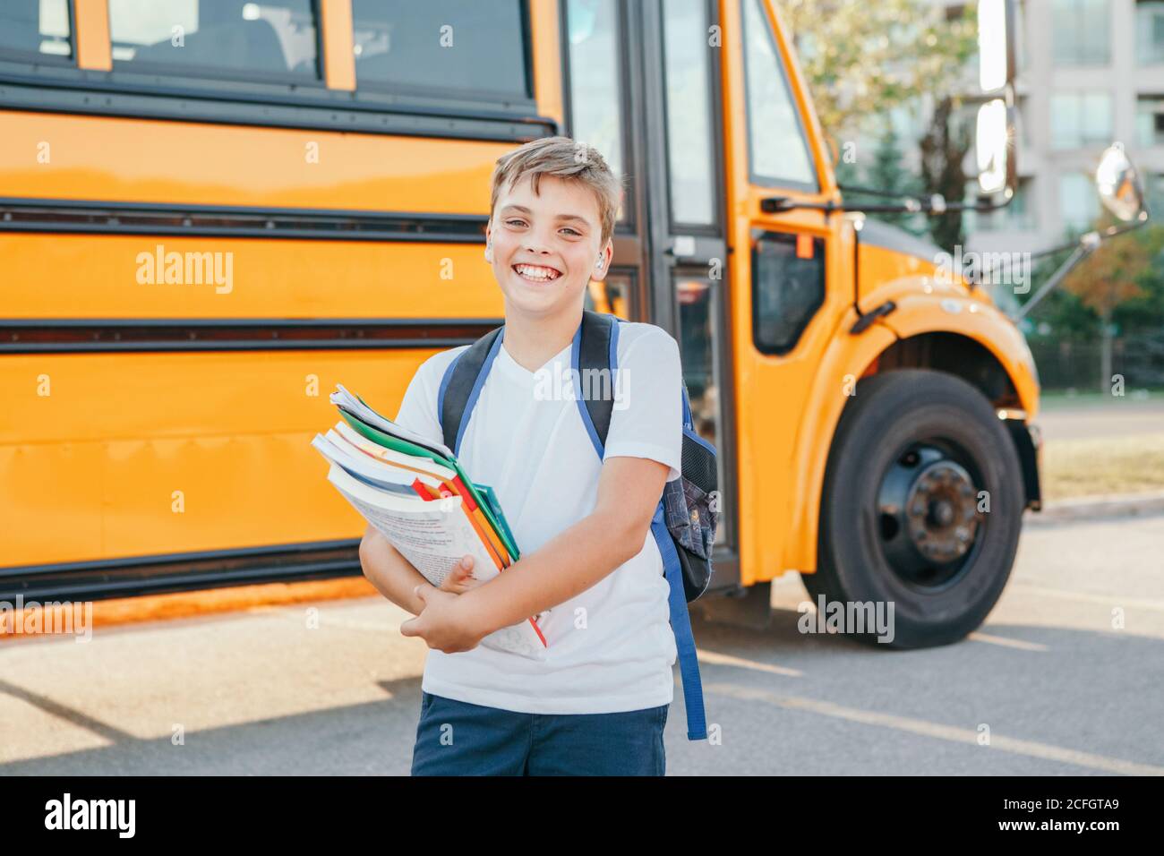 Happy Caucasian boy student with backpack and exrecise books near ...