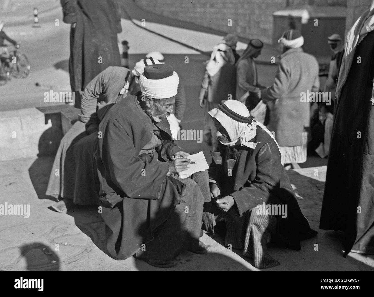 Middle East History - Sheik helping peasant to fill out ap[p]lication form for identity card Stock Photo