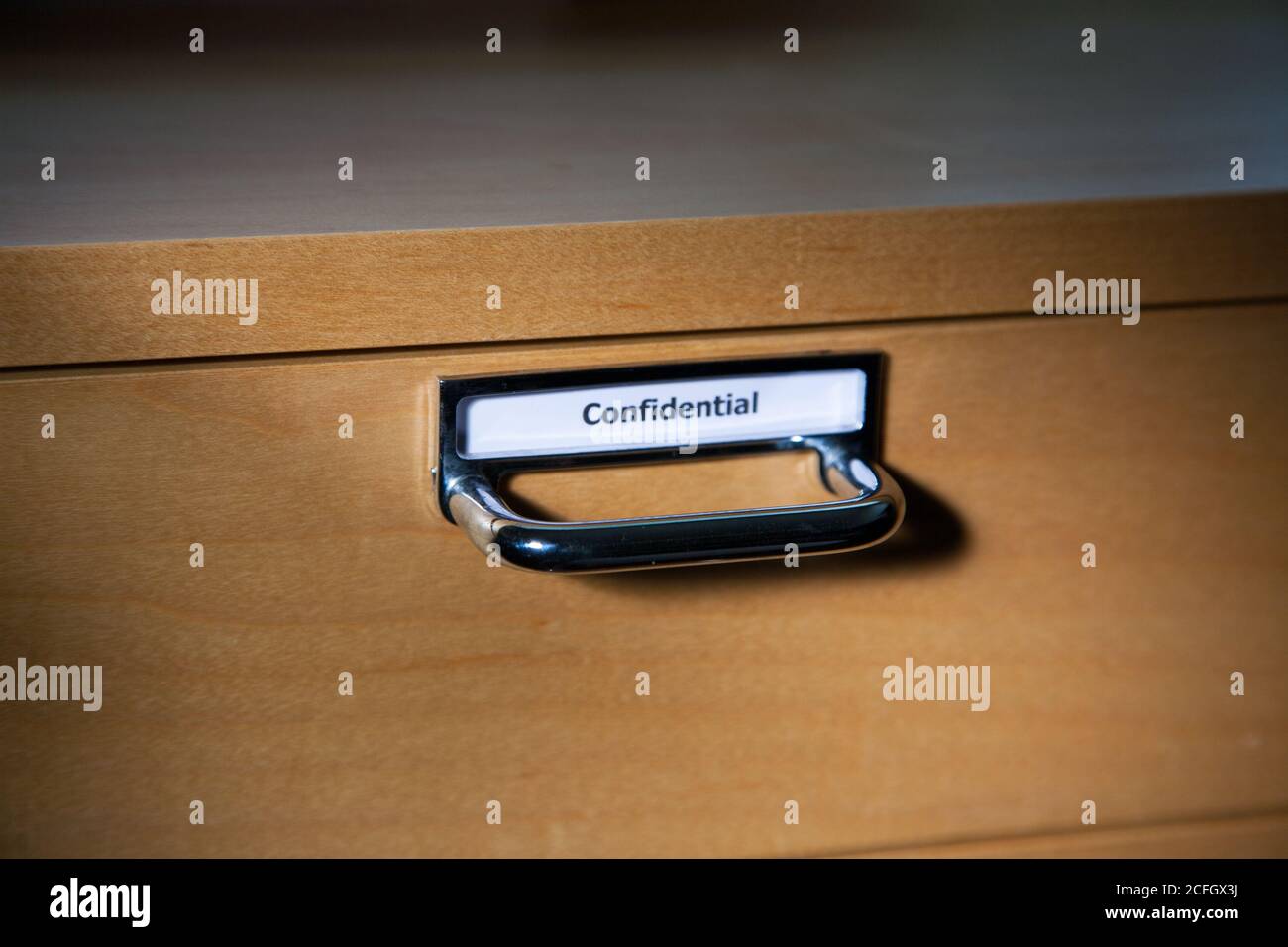 Wooden filing Drawer closed with Confidential sign Stock Photo
