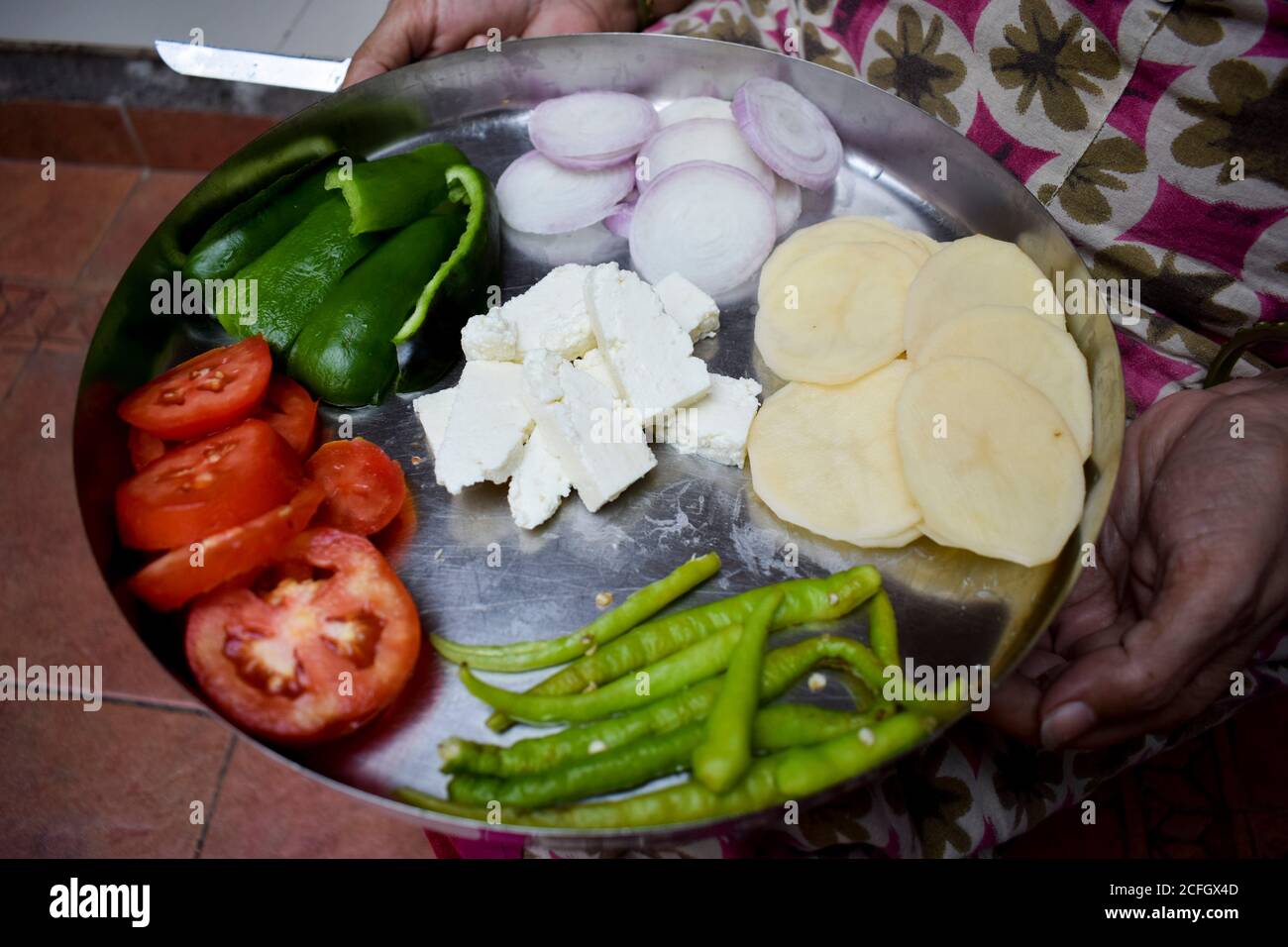 Indian woman chopping vegetables with both hands using knife. Cutting