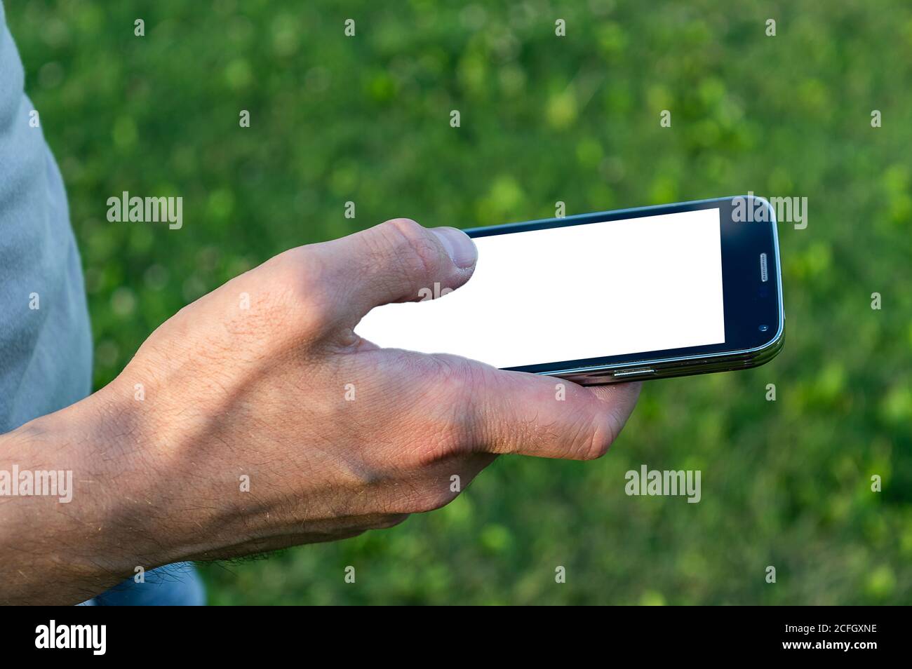 man hand holding black mobile phone with white screen Stock Photo