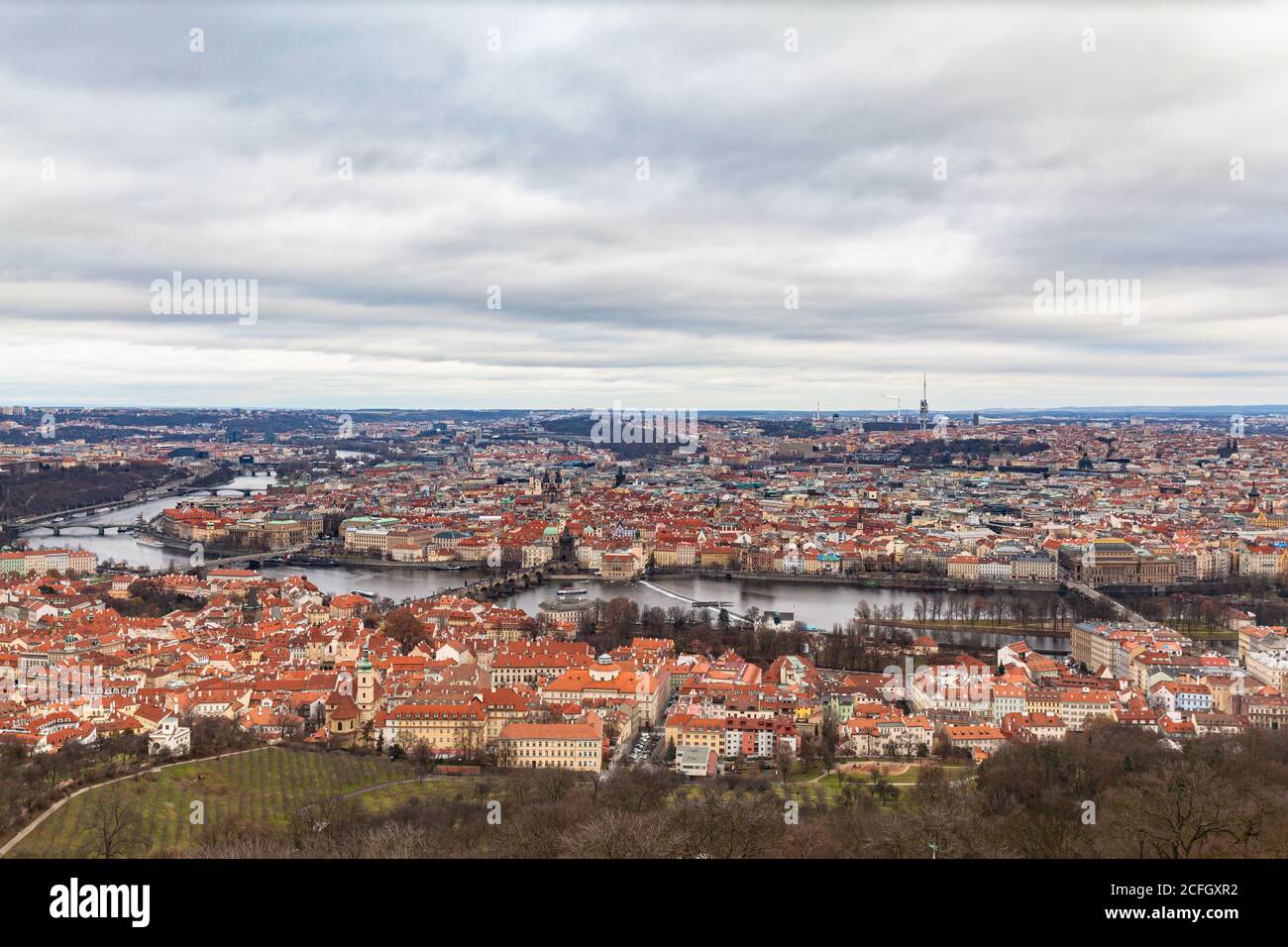 Aerial panorama view of Prague cityscape with many historic buildings and Vltava river flowing through the old town on a cloudy day from top of Petrin Stock Photo