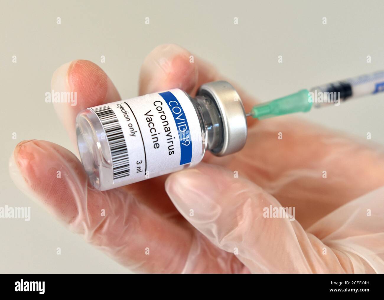 Coronavirus vaccine vial container in hand on white background. Close-up view. Coronavirus vaccine bottle. Stock Photo