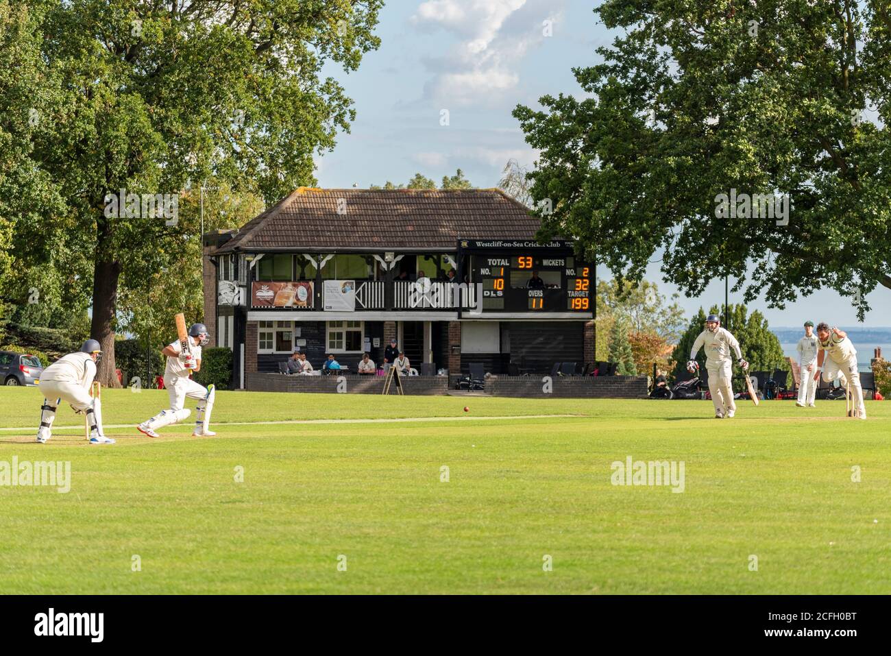 Cricket being played in Chalkwell Park, Westcliff on Sea, Southend, Essex, UK. Westcliff on Sea Cricket Club playing Southend. Clubhouse Stock Photo