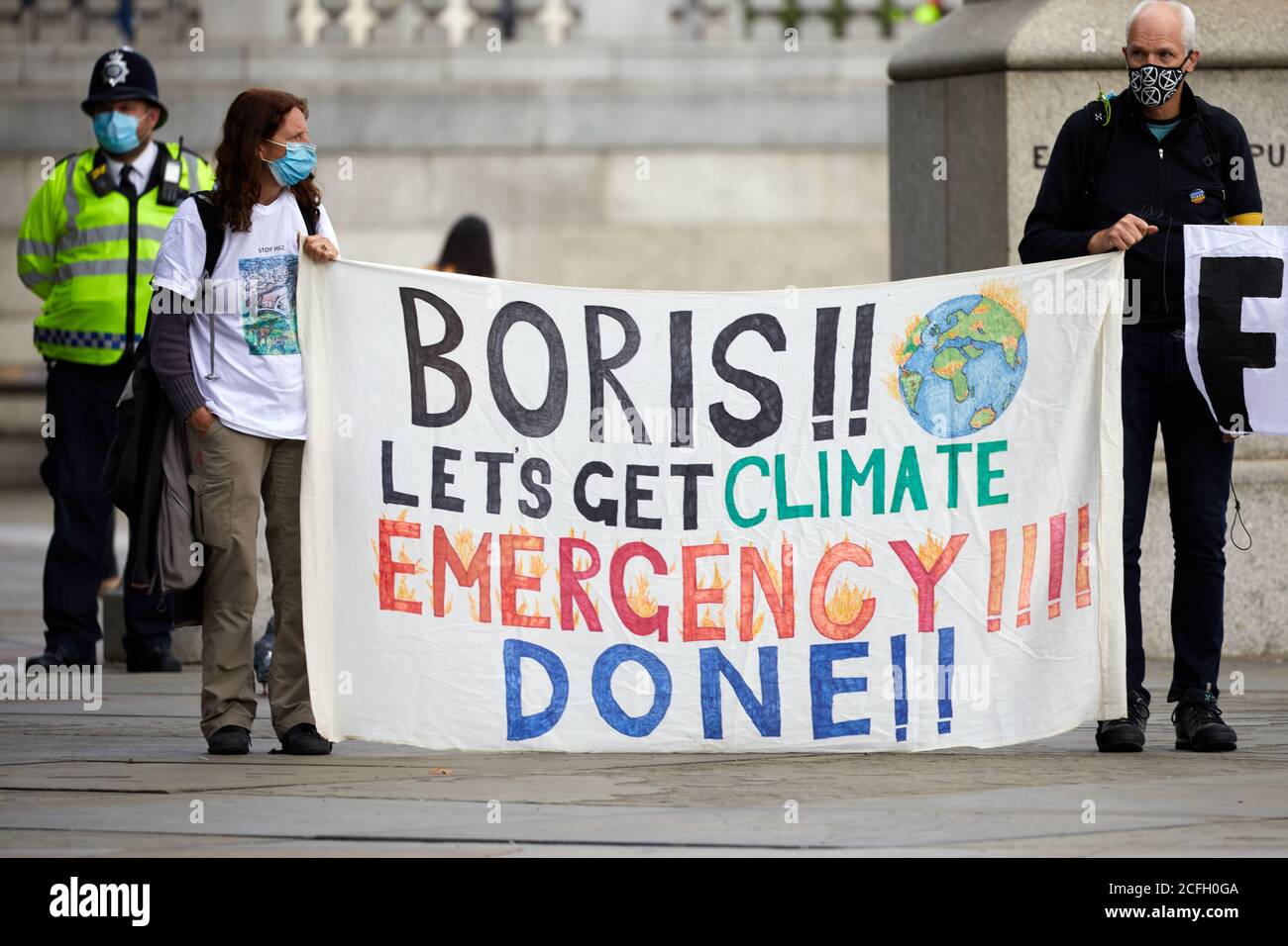 London, UK. - 5 Sept 2020: Protestors hold up banner - with a message aimed at prime minister Boris Johnson - at an Extinction Rebellion rally in Trafalgar Square. Stock Photo