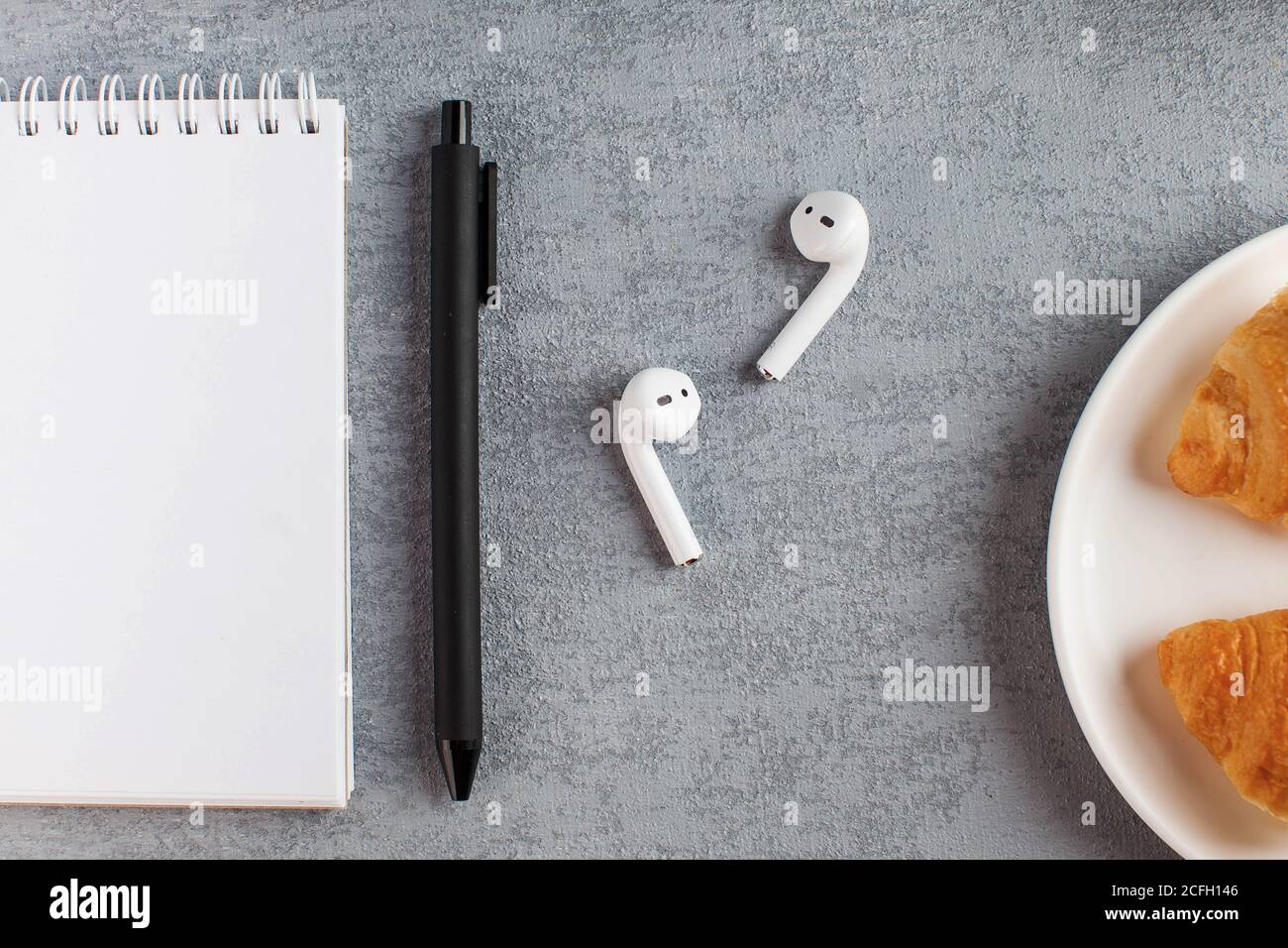 White Notepad, wireless headphones. The concept of online training, work from home, home office. Copy space. Stock Photo