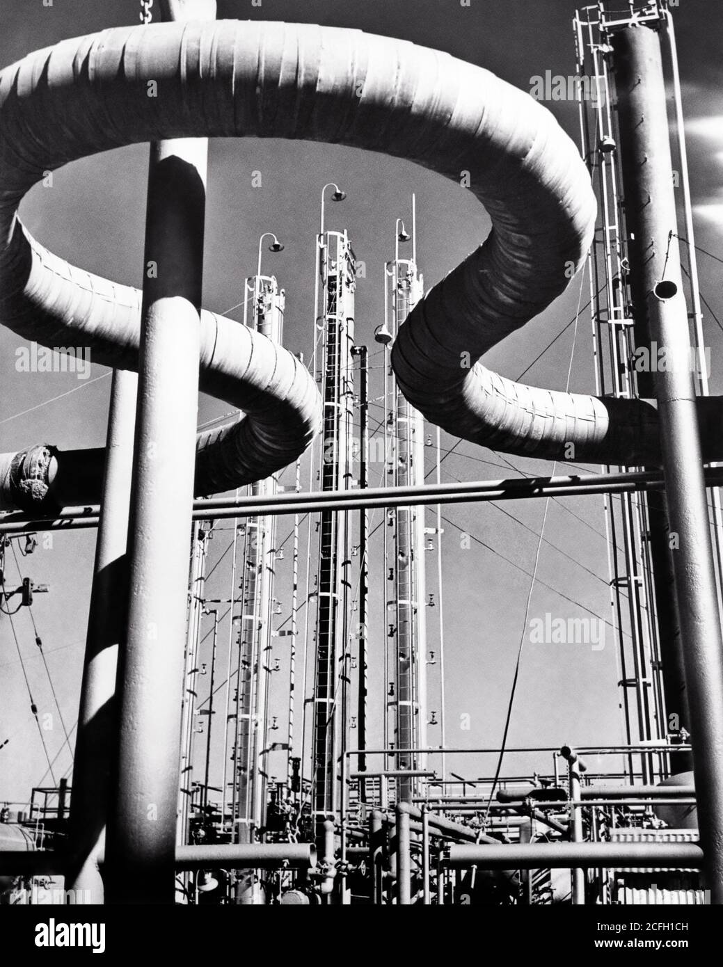 1940s PIPES AND FRACTIONATING TOWERS AT GASOLINE PLANT OIL REFINERY WORLD WAR 2 ERA DEFENSE PRODUCTION USA - i3991 HAR001 HARS TOWERS Stock Photo