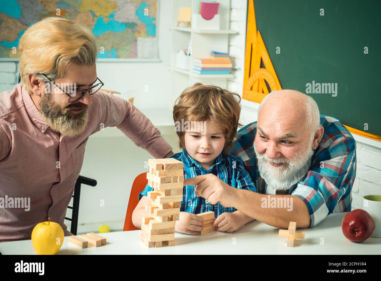 Male generations friendship. Happy little child father and grandparent leisure fun time. Grangfather, Father and son playing game at home. Stock Photo