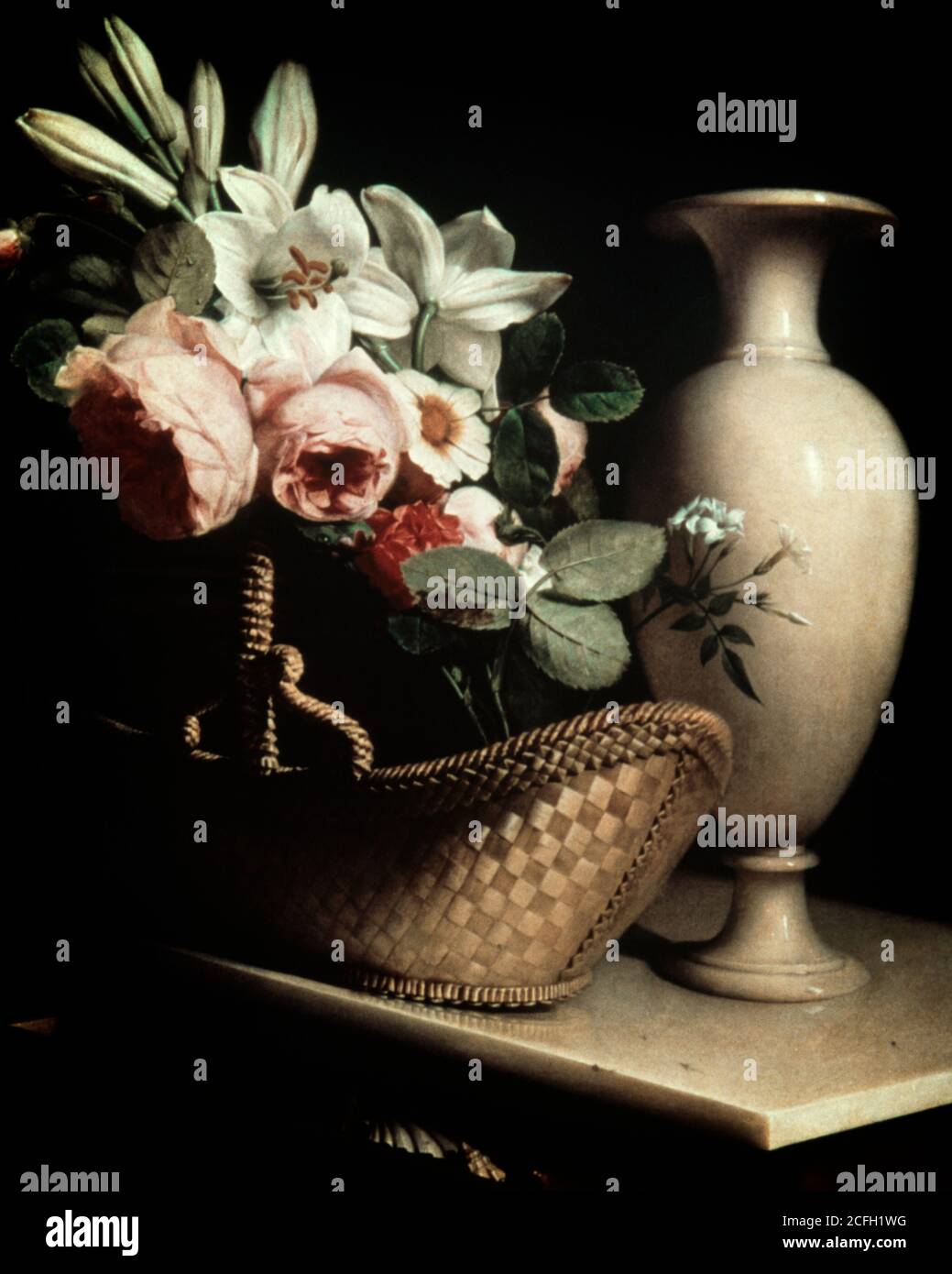 1970s WHITE LILIES PINK ROSES GERBER DAISY CLASSICAL STYLE FLOWER ARRANGEMENT IN ANTIQUE WOVEN BASKET BESIDE A MARBLE VASE - kf15195 PHT001 HARS POSH GERBER LILIES PLUSH AFFECTION CHARMING CLASSY CREATIVITY EMOTION EMOTIONAL EMOTIONS LONGING SMOOTH WISTFUL WOVEN LUSH OLD FASHIONED SUBLIME Stock Photo
