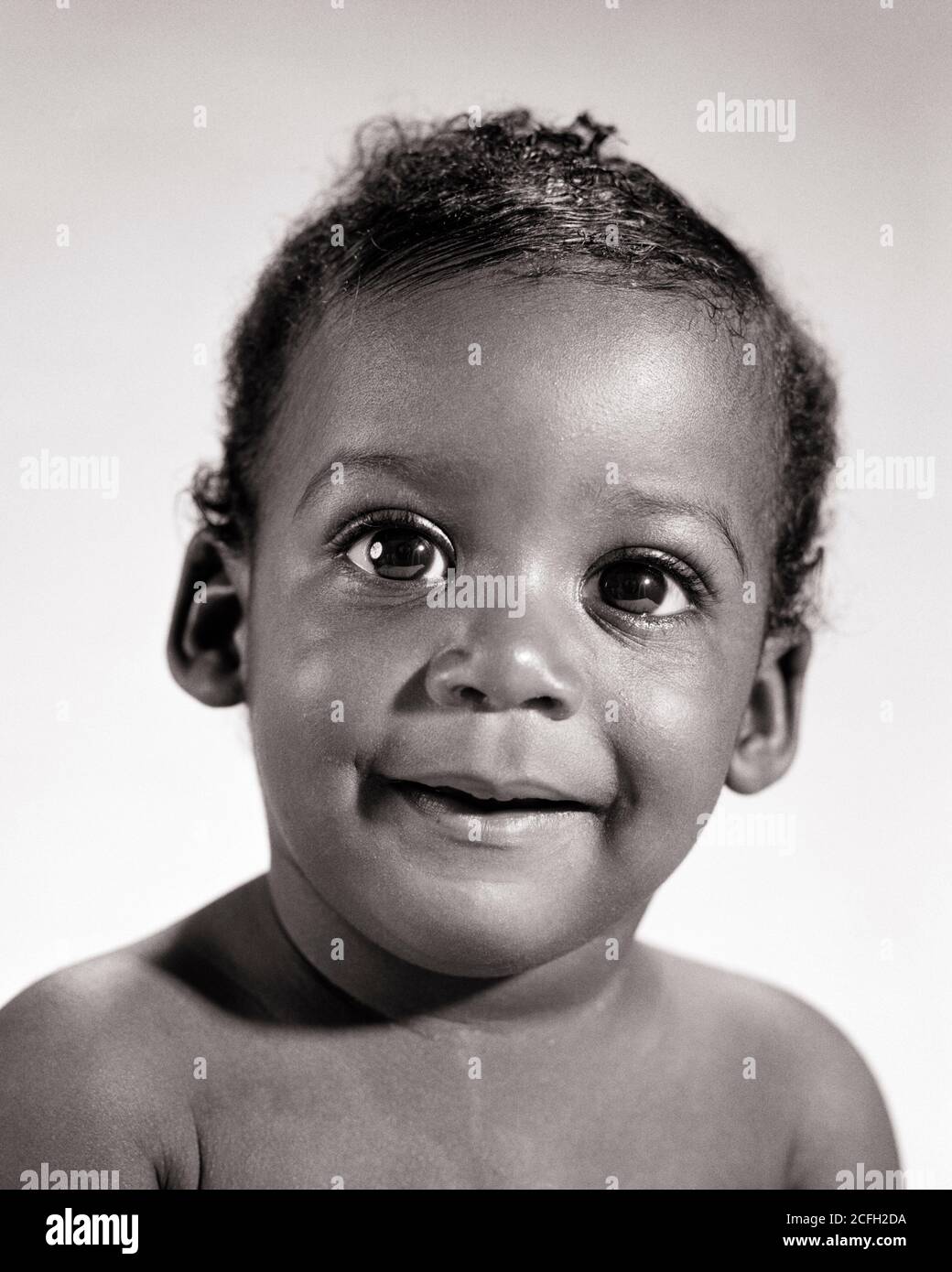 1960s PORTRAIT SWEET AFRICAN-AMERICAN BABY BOY WITH BIG EYES SMILING LOOKING AT CAMERA - n2325 HAR001 HARS B&W EYE CONTACT BUG-EYED HAPPINESS HEAD AND SHOULDERS CHEERFUL DISCOVERY AFRICAN-AMERICANS AFRICAN-AMERICAN BLACK ETHNICITY SMILES JOYFUL BABY BOY PLEASANT WIDE-EYED AGREEABLE CHARMING GROWTH JUVENILES LOVABLE PLEASING ADORABLE APPEALING BLACK AND WHITE HAR001 OLD FASHIONED AFRICAN AMERICANS Stock Photo