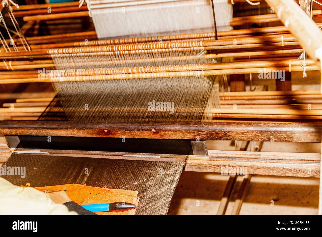 working a loom, scene in silk factory in Cambodia. Silk direct from the cocoons of silk worms. Silk fabric was invented in Ancient China and played an Stock Photo