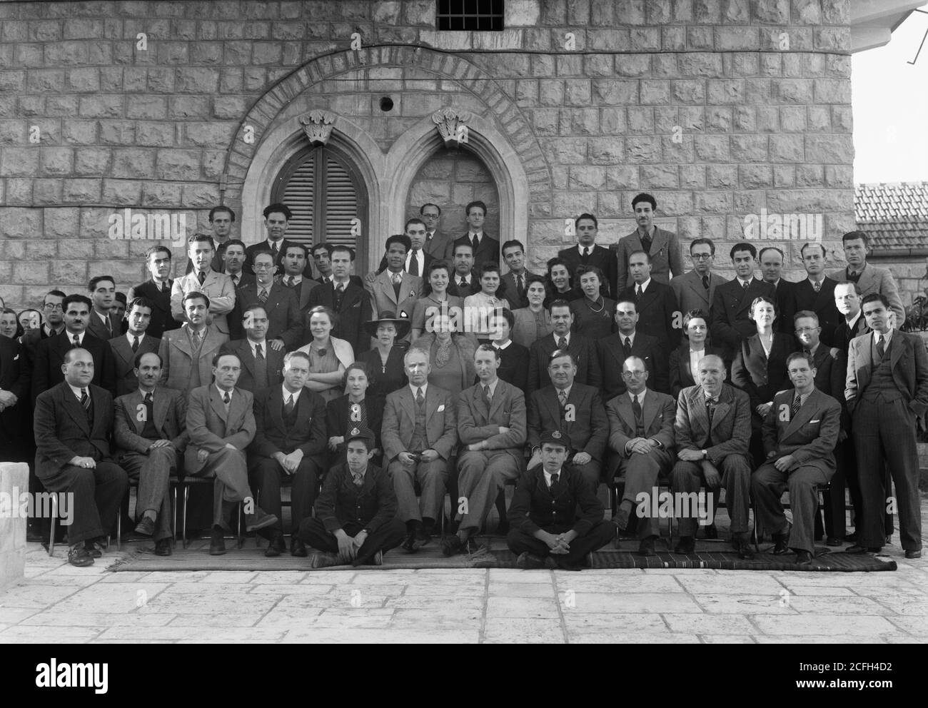Original Caption:  Group at P.B.S. [i.e. Palestine Broadcasting Service] Mr. Pastou's farewell Mar. 1942  - Location: Jerusalem ca.  1942 Stock Photo
