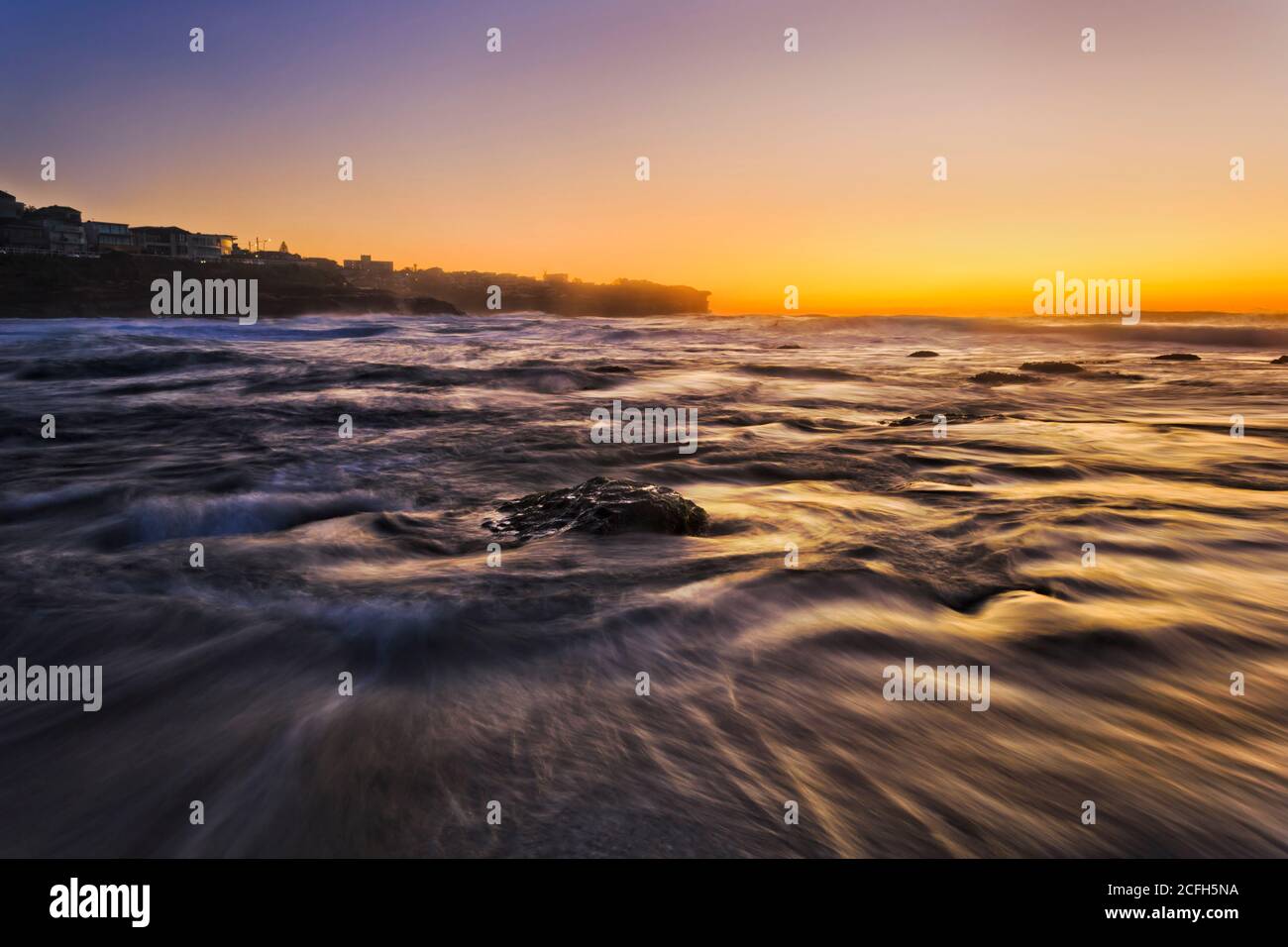 Hot orange sunrise over Pacific ocean horizon at Bronte beach of Sydney eastern suburbs. Stock Photo