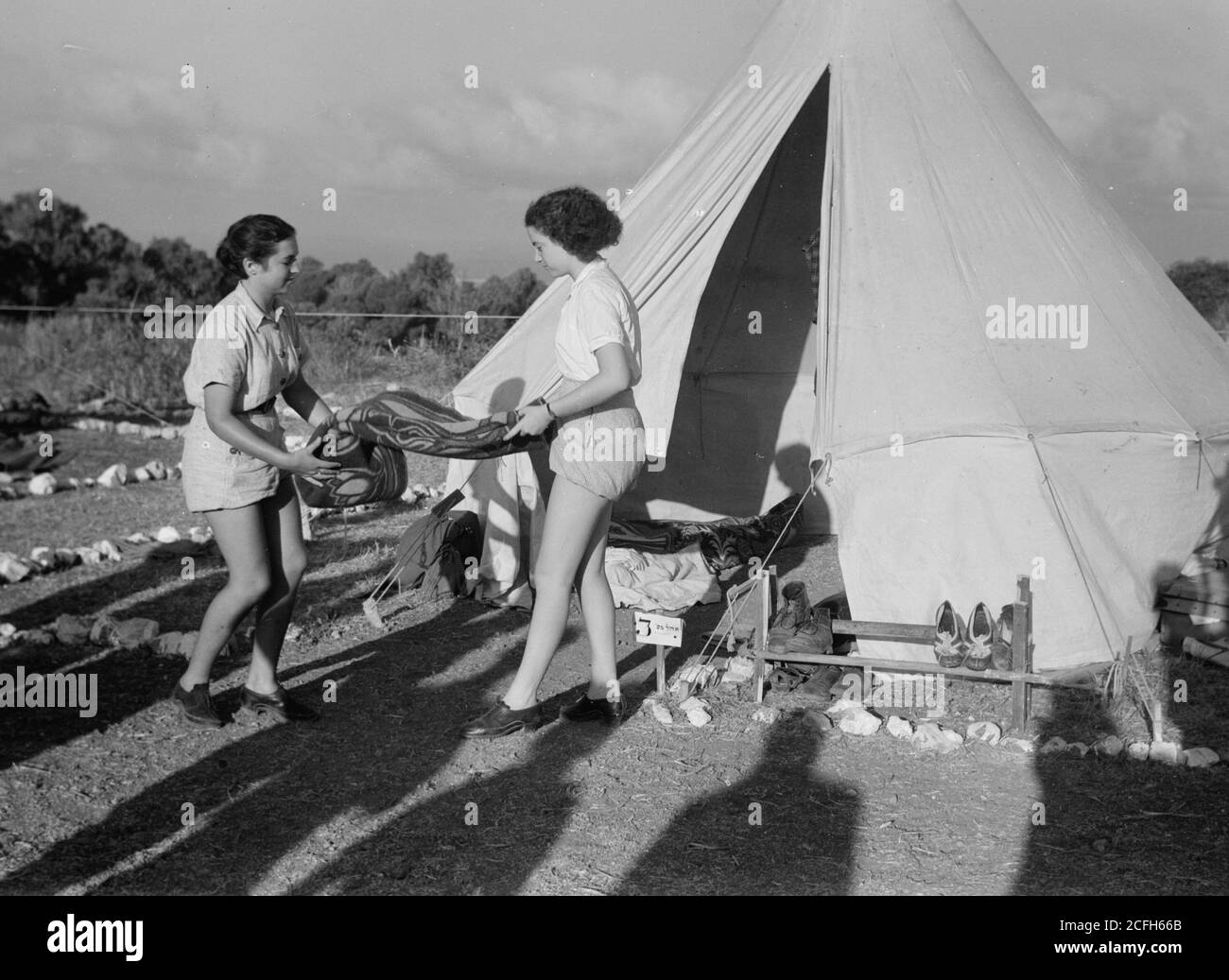 Original Caption:  The vintage season Zikh'ron Ya'aqov July 24 1939. Camp girls tidying up their tent  - Location: Israel--Zikhron YaÊ»aá¸³ov ca.  1939 Stock Photo