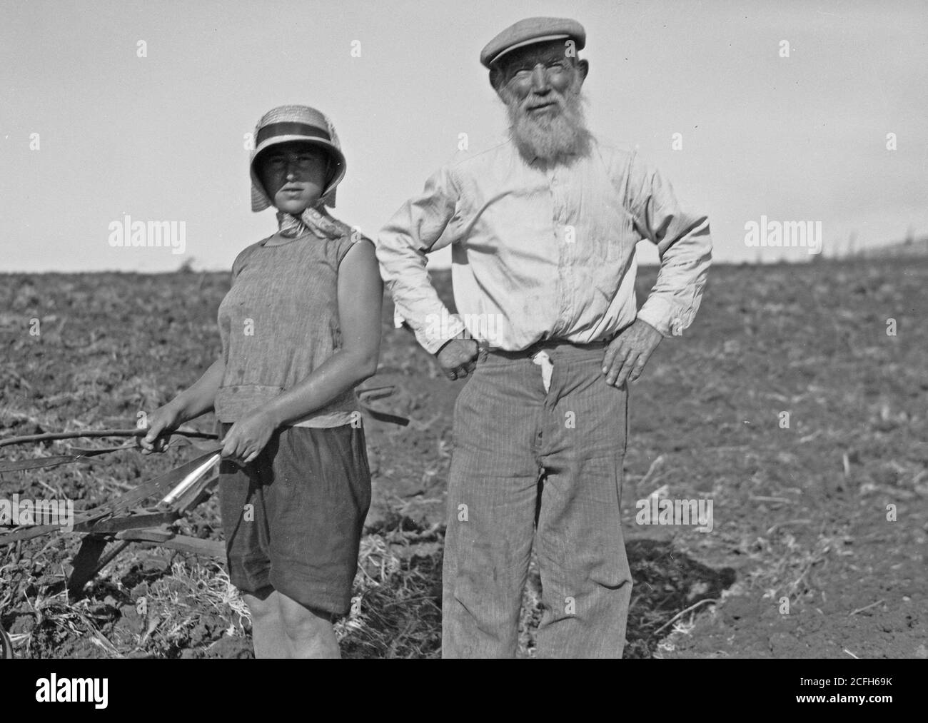'Middle East History - The Keren Hayesod. Agricultural Colonies on Plain of Esdraelon ''The Emek.'' Zionist agricultural zeal. Grandfather helping grand-daughter to plow' Stock Photo