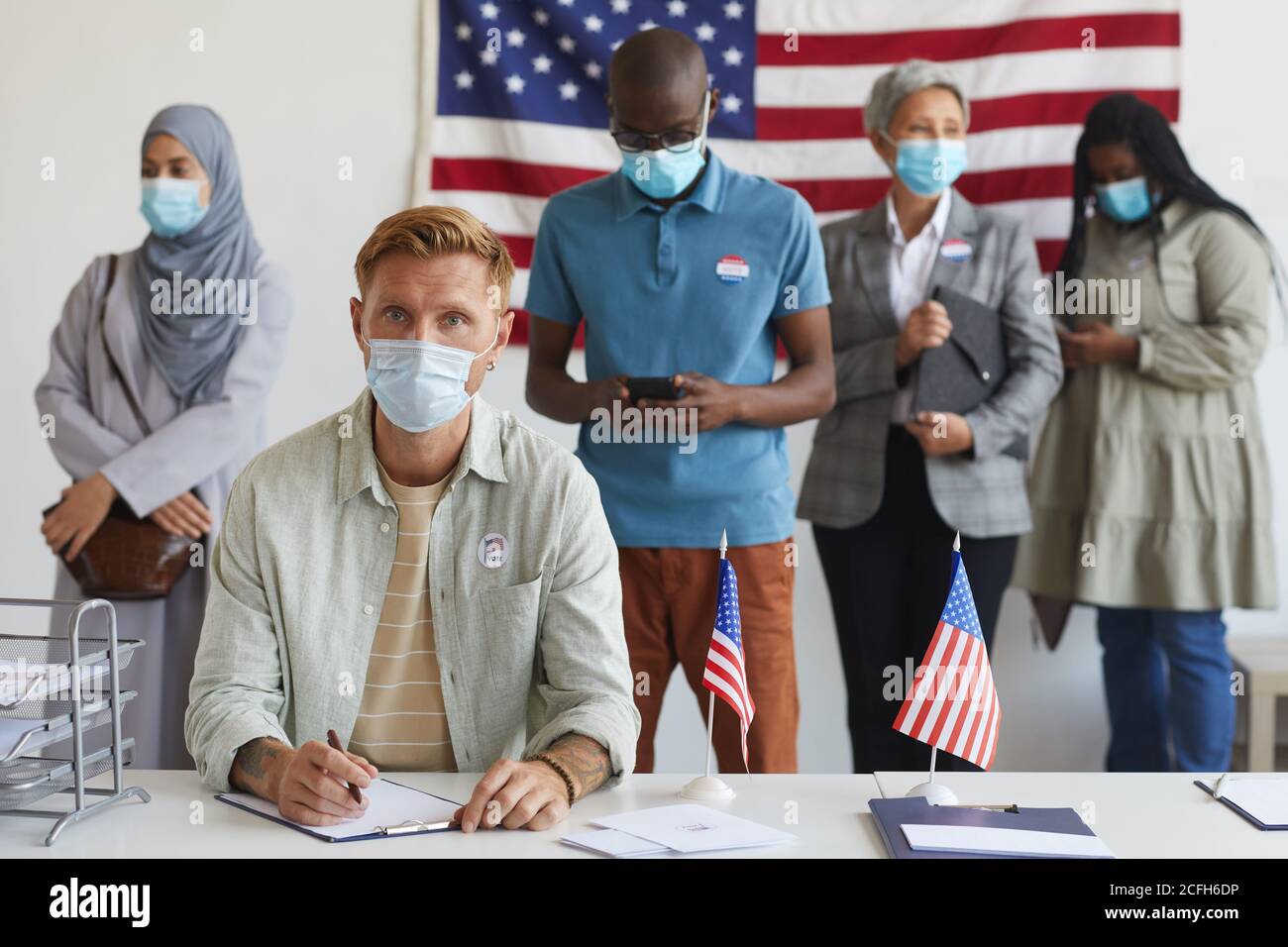 Multi-ethnic group of people standing in row and wearing masks at ...