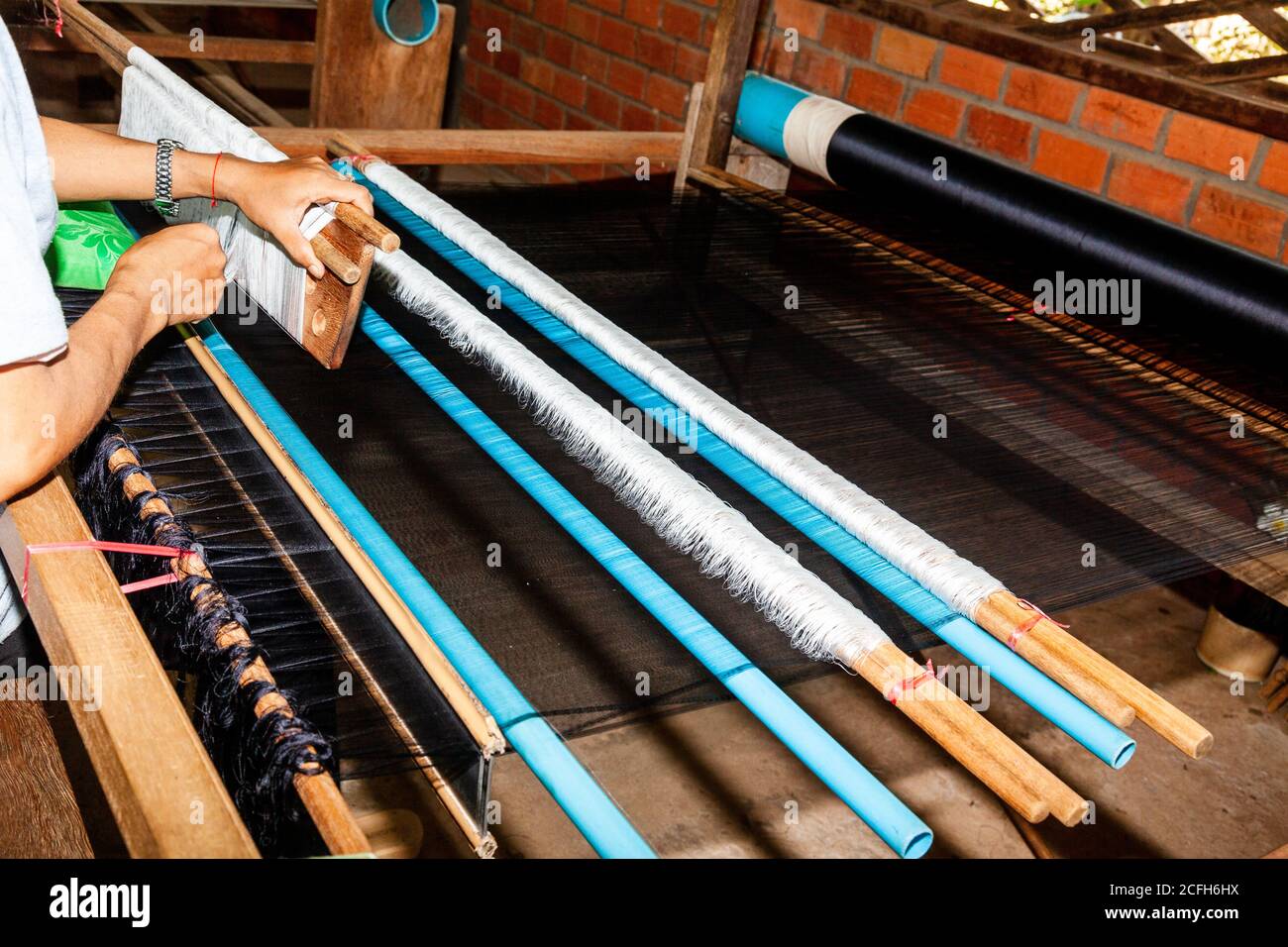 working a loom, scene in silk factory in Cambodia. Silk direct from the