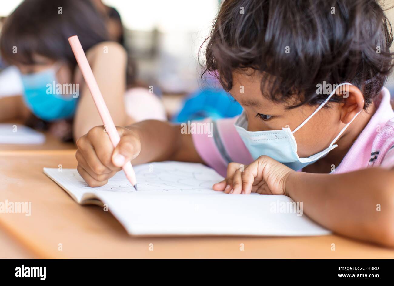 school boy wearing mask and study in classroom Stock Photo - Alamy