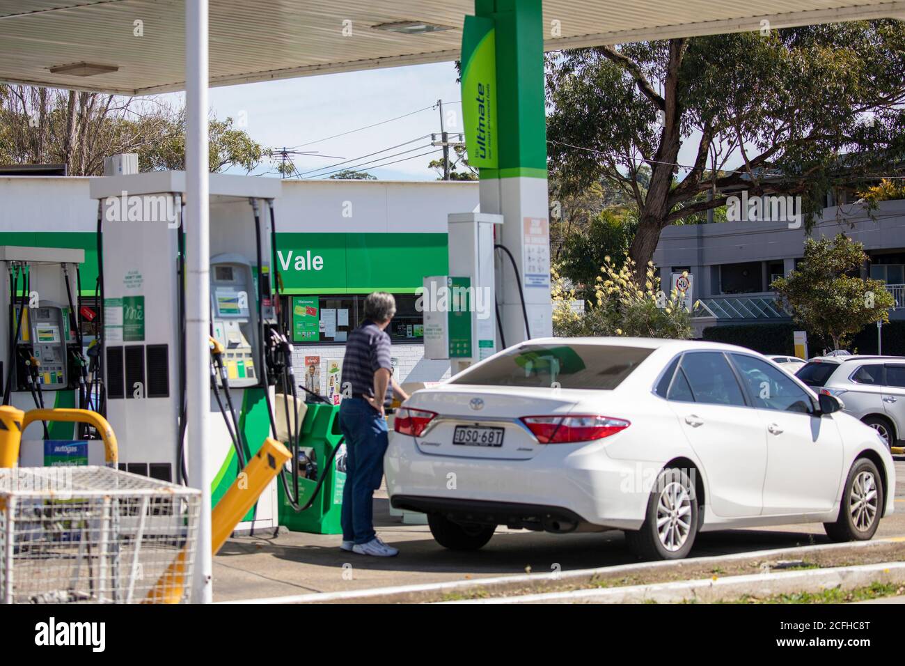 Australian man at a BP petrol service station fills his car up with fuel gasoline,Sydney,Australia Stock Photo